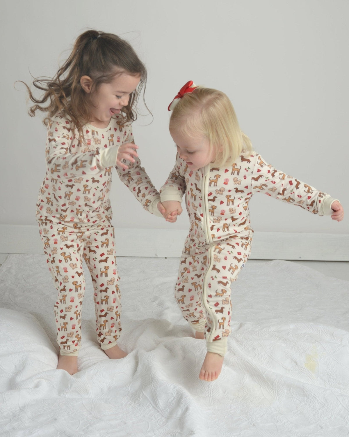 Toddler dog-print pajama romper with front zipper, long sleeves, and footed cuffs, cream