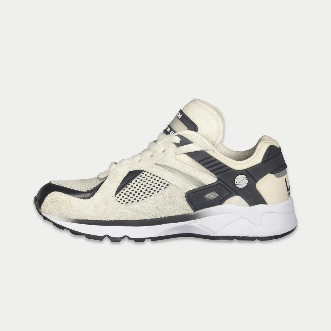 Women’s white and black lace-up lowtop sneakers with dark overlays and white midsole.