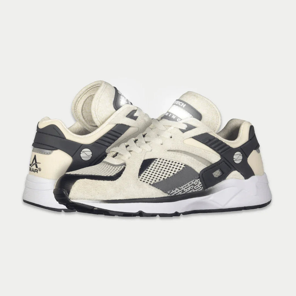 Women’s white and black lowtop sneakers, side view, lace-up with sporty mesh panels.