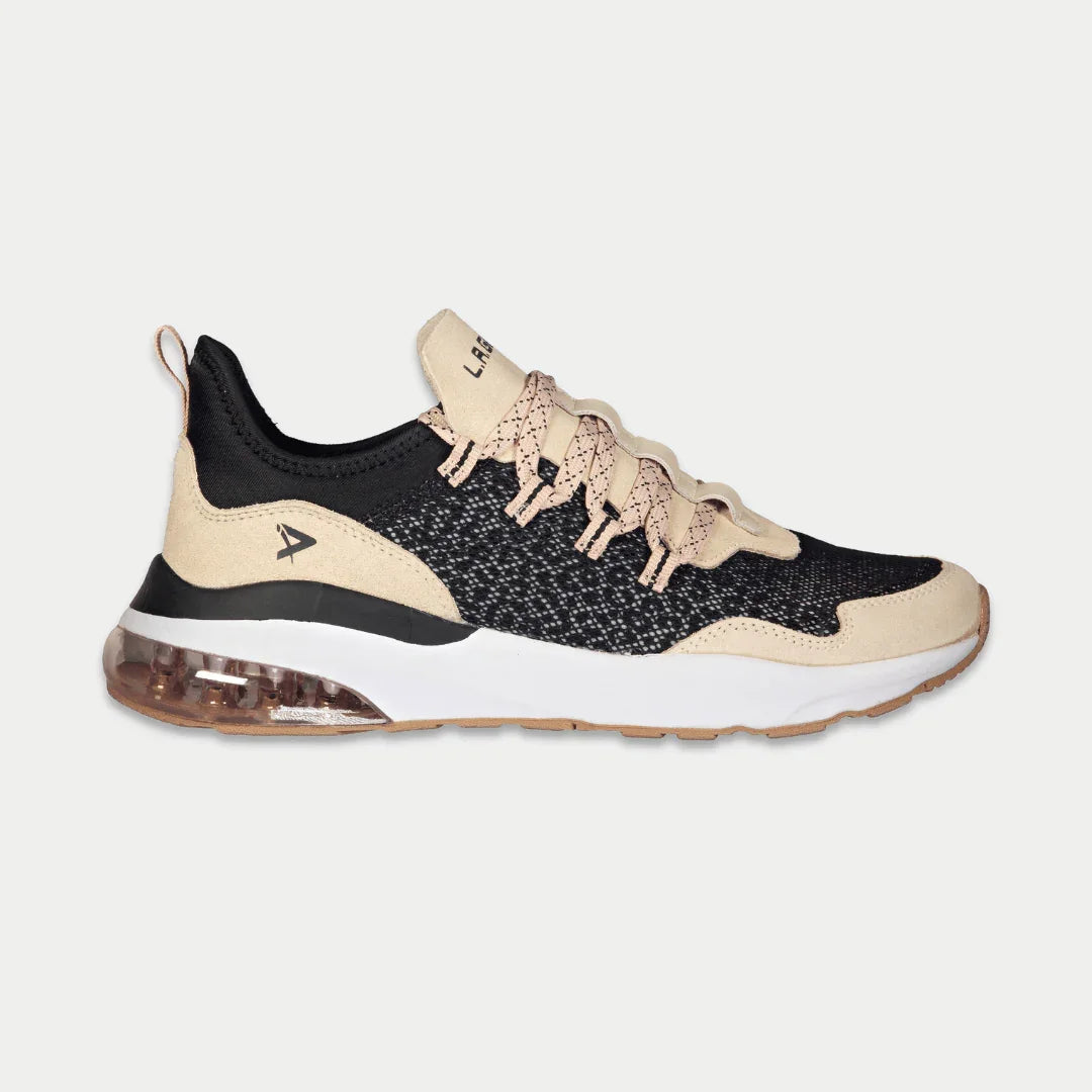 Women’s low-top running sneaker in black, tan, and pink accents with air-cushion sole