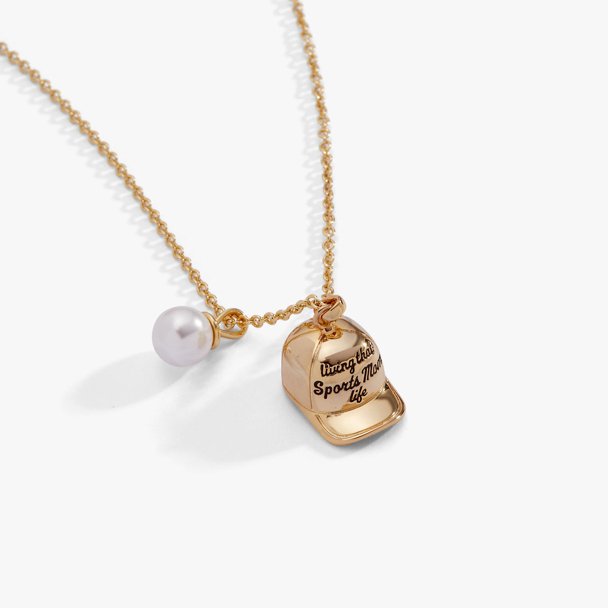Gold baseball charm necklace with pearl bead and baseball-cap charm, close-up