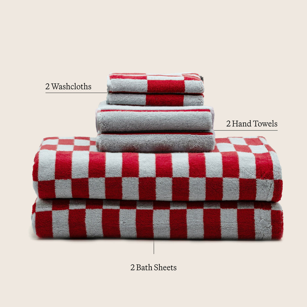 Rolled and folded cotton towels with red-and-white check layer and gray terry layers.