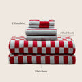 Rolled and folded cotton towels with red-and-white check layer and gray terry layers.