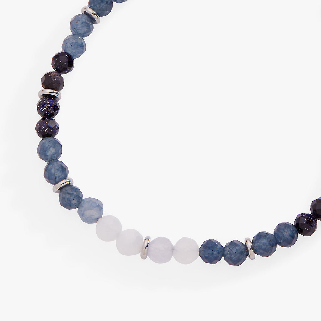 Blue ombre beaded anklet close-up, alternating dark blue, light blue, and white faceted beads