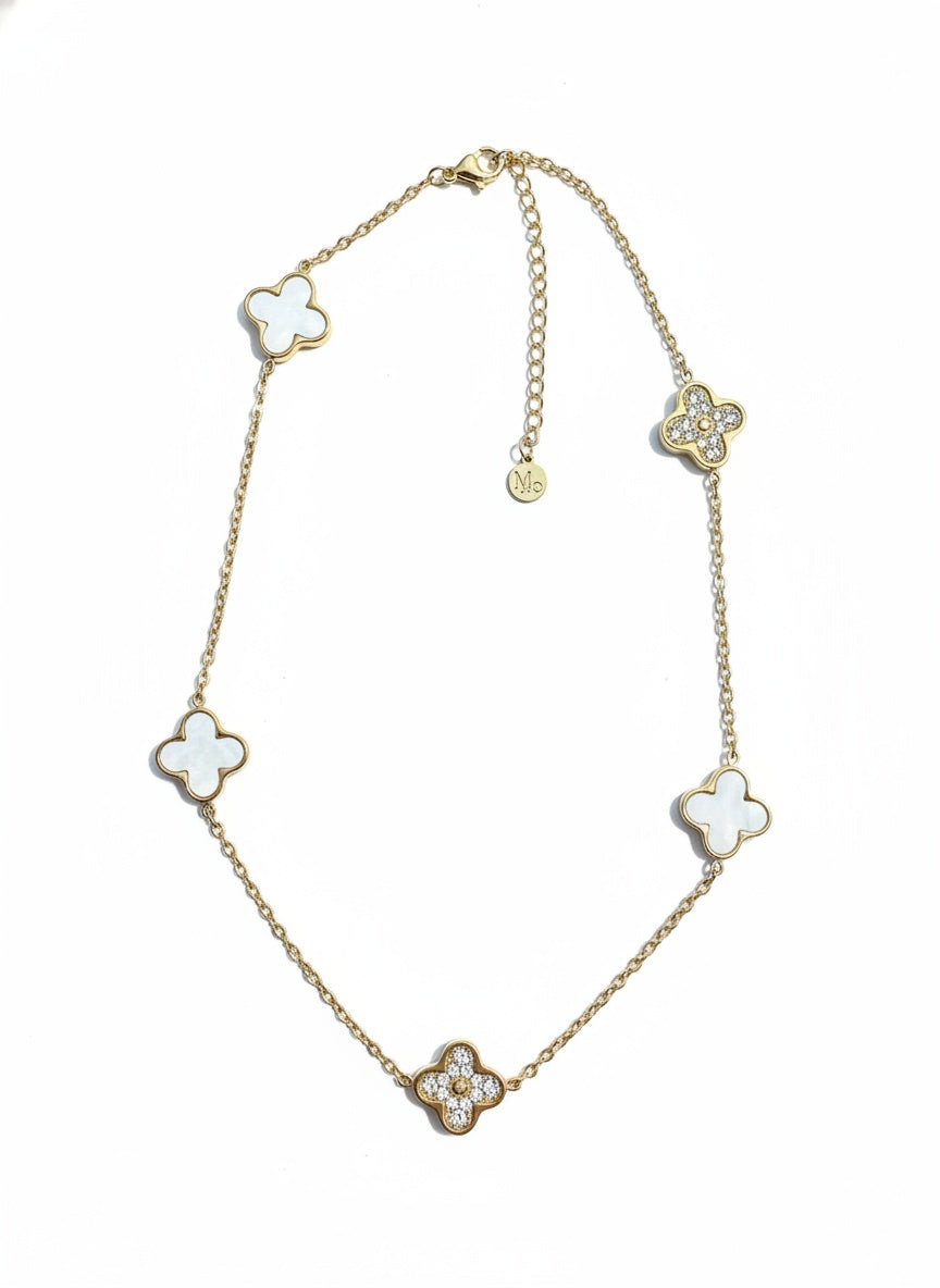 Gold-tone charm necklace with four clover motifs and small round accents