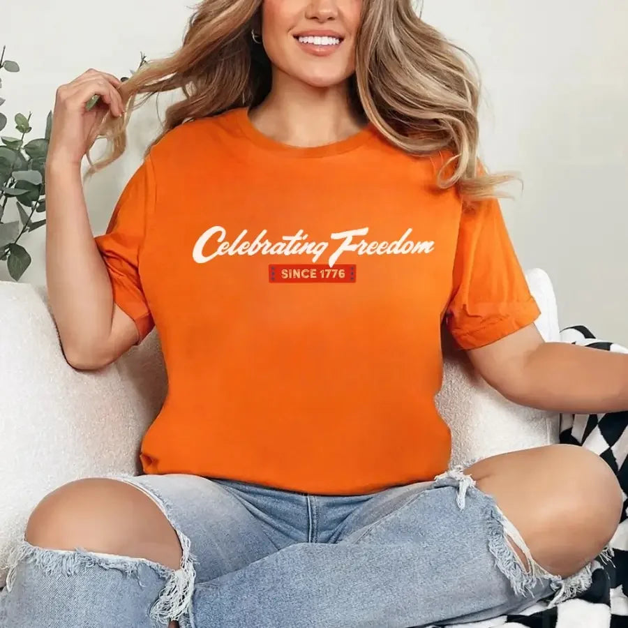 Orange graphic t-shirt with “Celebrating Freedom” and “Since 1776” print