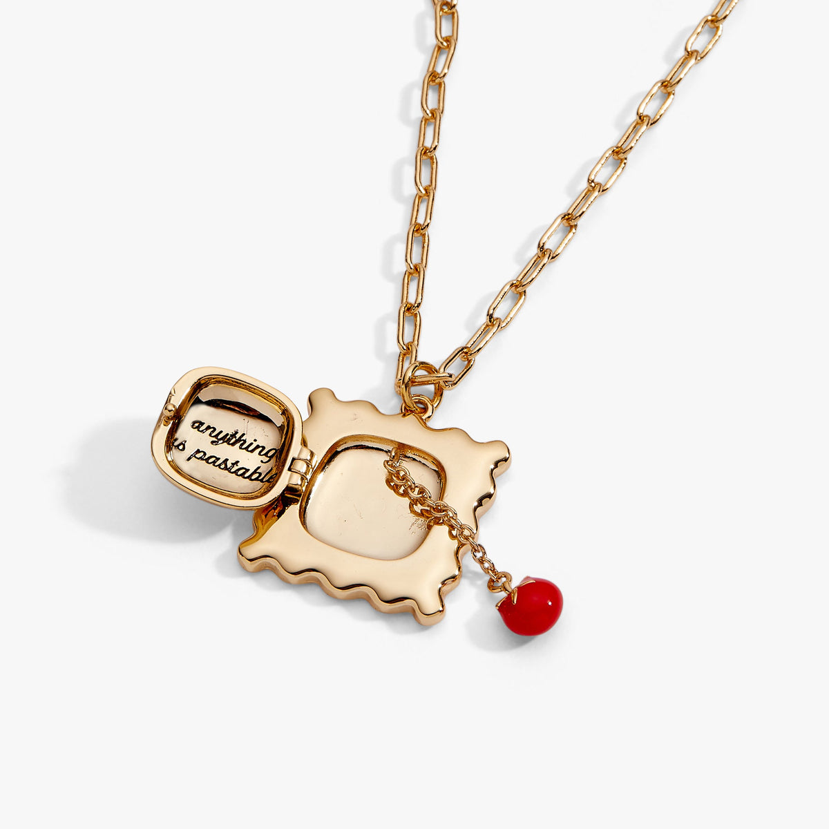 Gold locket pendant with reflective center, dangling red bead charm and small quote disc