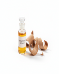 Sandalwood extract fragrance spritz bottle with amber liquid and sandalwood pieces