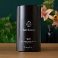 Black cylindrical tea tin with front label and gold variety text