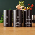 Luxury single-origin tea gift set with three black canisters: Gold, Emerald, Black Pearl
