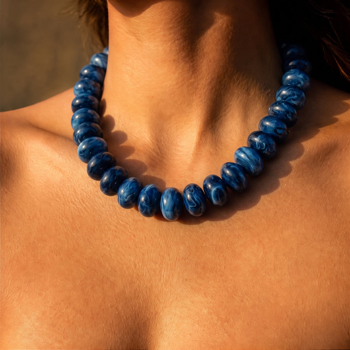 Blue beaded necklace with rounded beads and a snug collar fit.