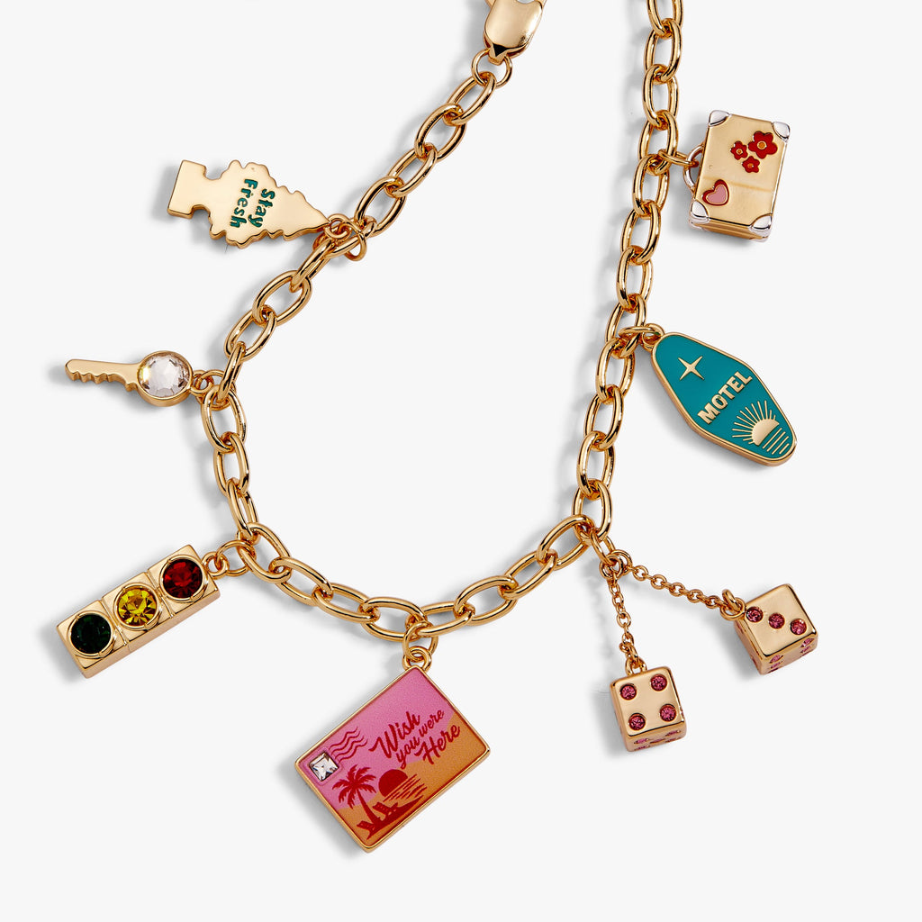 Gold chain bracelet featuring several rectangular travel-themed charm pendants