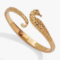 Gold-toned seahorse bypass cuff bracelet with textured links and small crystal accent