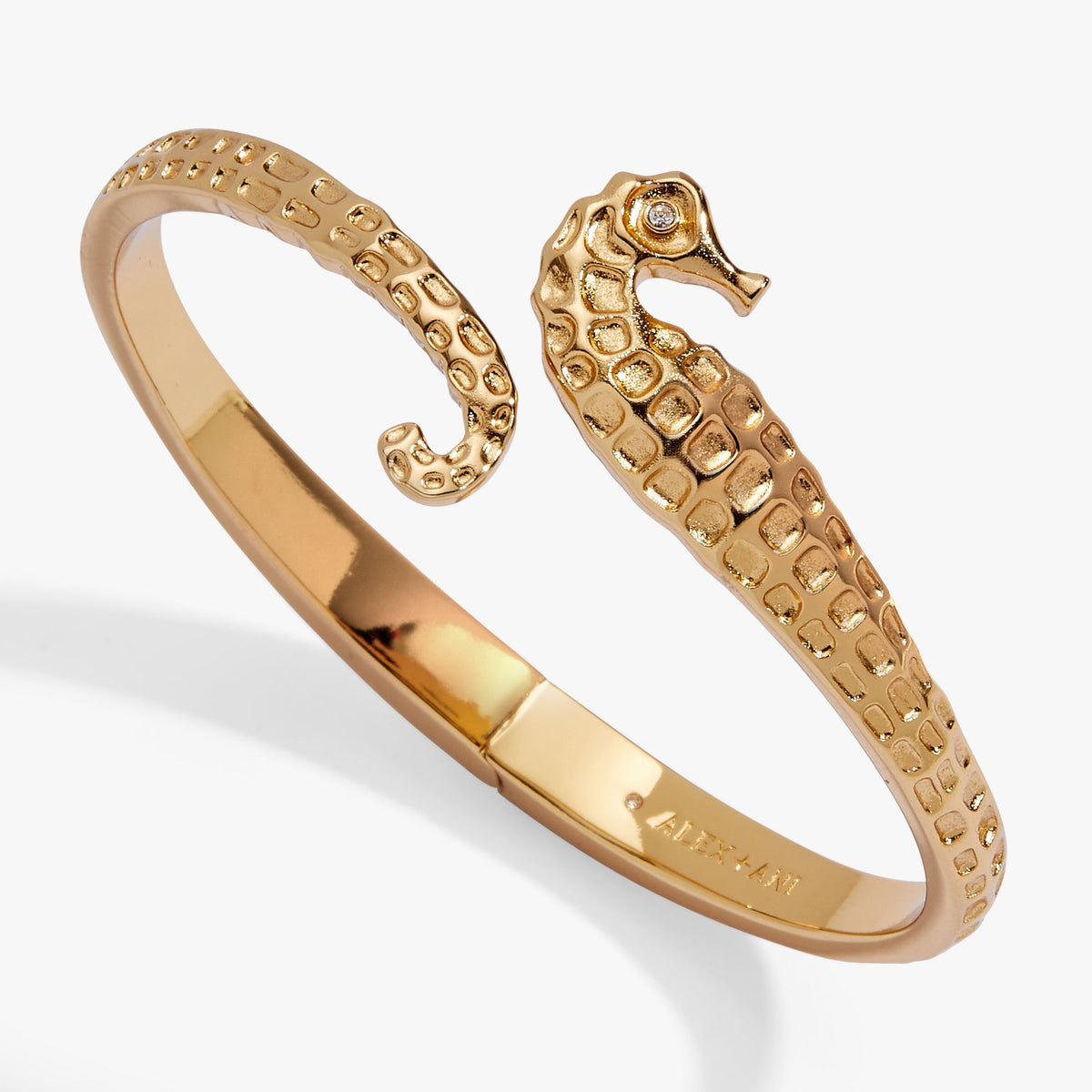 Gold-toned seahorse bypass cuff bracelet with textured links and small crystal accent