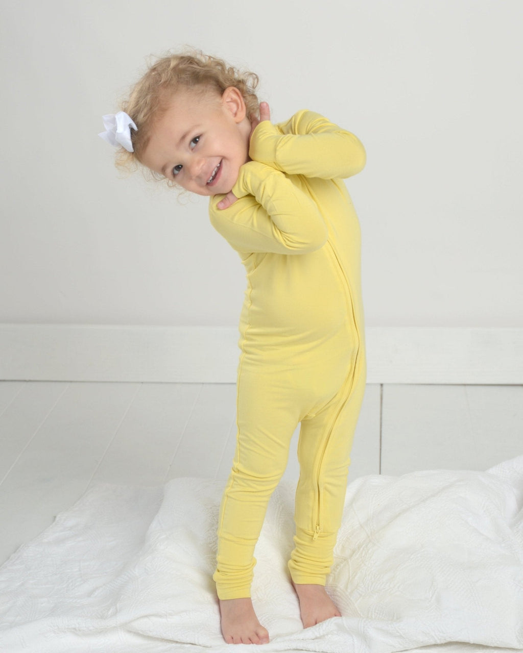 Yellow toddler romper pajamas with long sleeves, footed cuffs, and front zipper