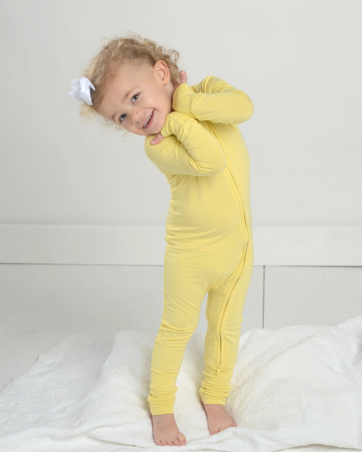 Yellow toddler romper pajamas with long sleeves, footed cuffs, and front zipper