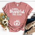 Mauve crewneck tee: 'Super thankful this year' with paw-heart icon, knotted hem