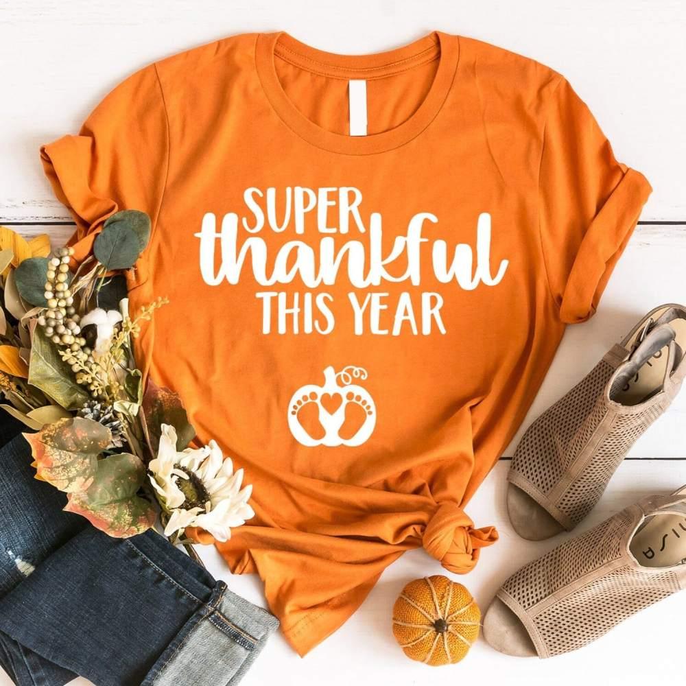 Burnt orange crewneck tee: 'Super thankful this year' with paw-heart icon, knotted hem