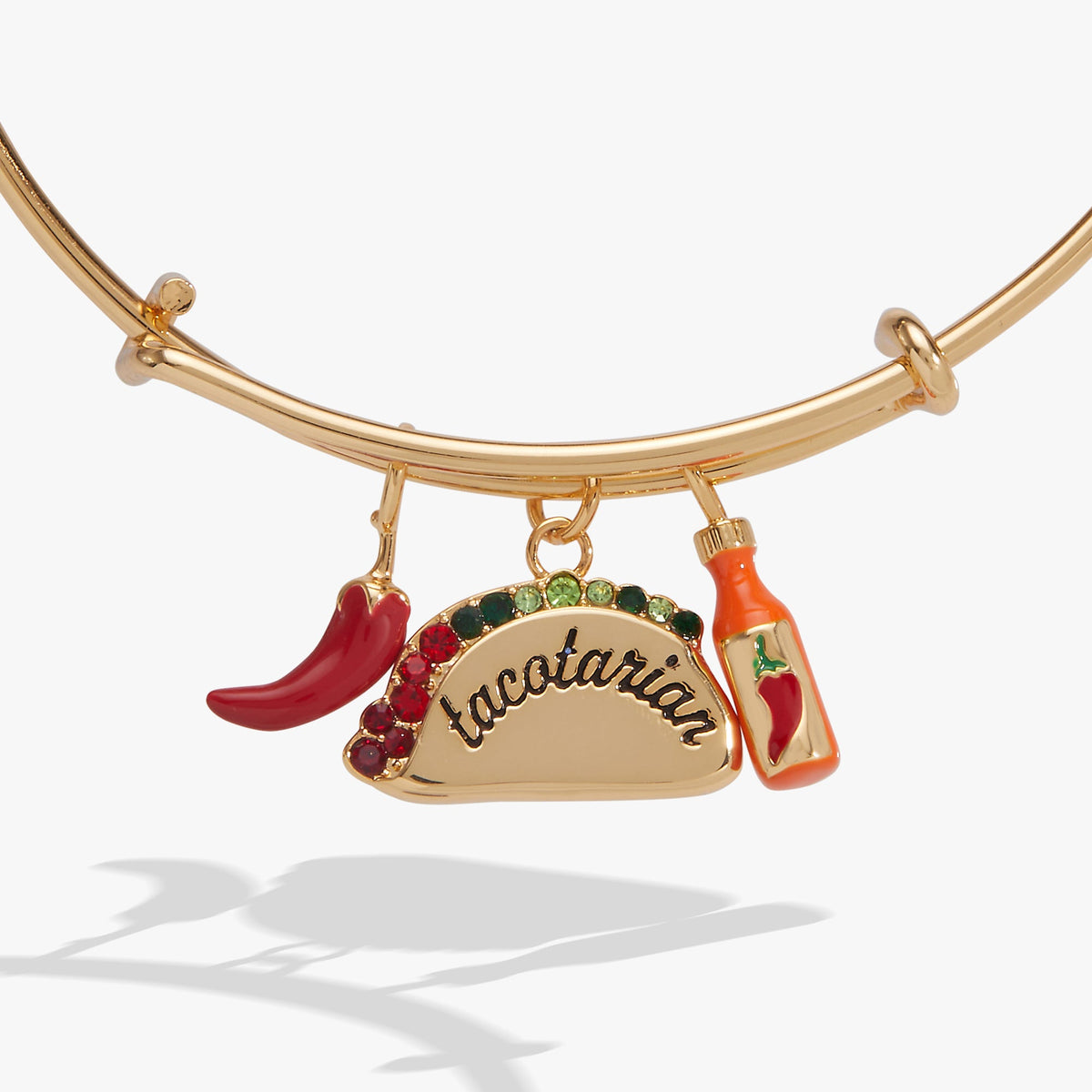 Gold bangle with taco charm, chili pepper, and bottle charm