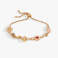 Gold-tone bolo bracelet with heart, pearl, and tea-themed charm beads