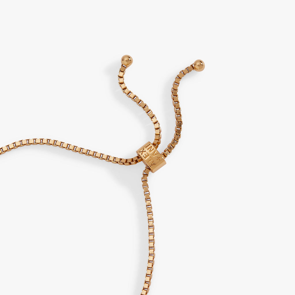 Gold-tone bolo bracelet with link chain and engraved charm at slider